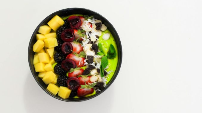 Delicious mixed fruit bowl with mango, blackberry, and cherry atop a creamy base. Perfect for a healthy diet.