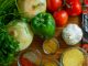 An assortment of fresh vegetables and spices on a wooden table for healthy cooking.